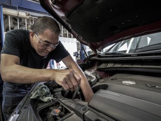 Ein Mechaniker arbeitet in einer Werkstatt an einem Motor